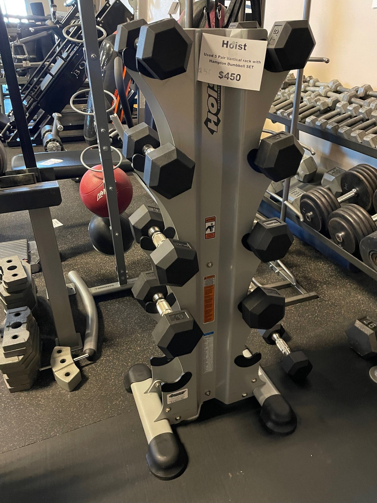 Used Hoist vertical stand loaded with Hampton urethane hex dumbbells